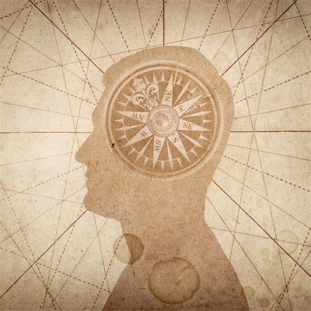 An illustrated head in profile with a compass inside it